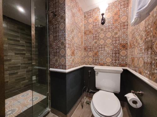 a bathroom with a toilet and a shower at The Quba Boutique Hotel Pattaya in Pattaya Central