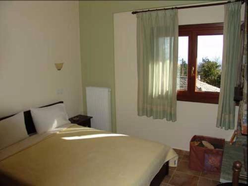 a bedroom with a large bed and a window at Hotel Erotas in Agios Dimitrios