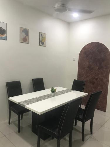 a meeting room with a white table and chairs at Koolest homestays Meru in Ipoh