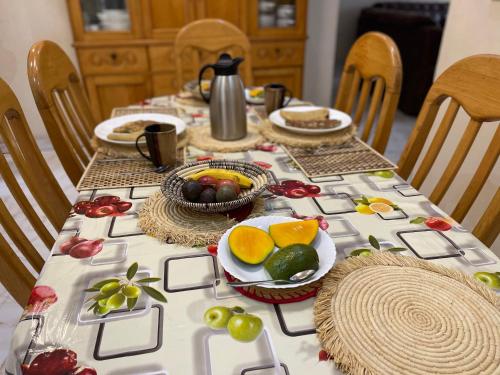 - une table avec des fruits et des assiettes de nourriture dans l'établissement Virunga Homestays, à Ruhengeri