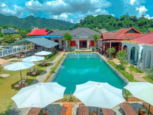 einen Luftblick auf einen Pool mit Sonnenschirmen des Resorts in der Unterkunft Green Town Mộc Châu in Mộc Châu