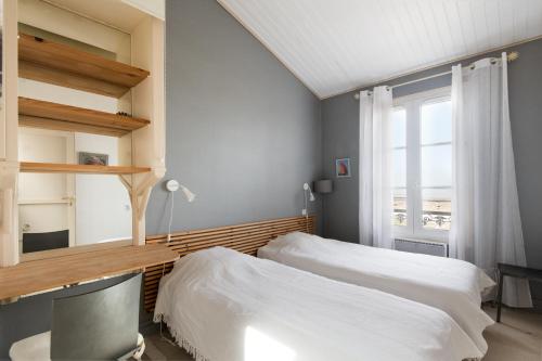 a bedroom with two beds and a window at Appartement Neptune in Saint-Martin-de-Ré