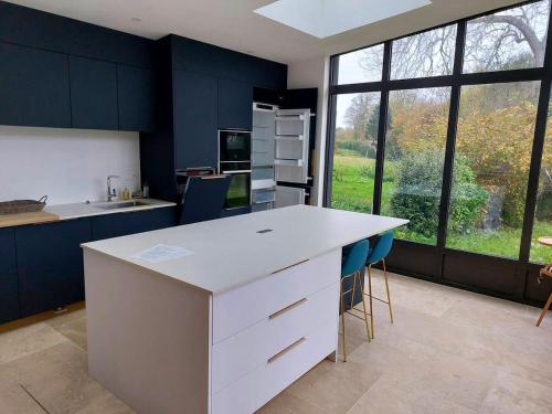 eine Küche mit einer weißen Theke und blauen Schränken in der Unterkunft Maison de 4 chambres avec jardin clos a Saint Cast le Guildo a 1 km de la plage in Saint-Cast-le-Guildo