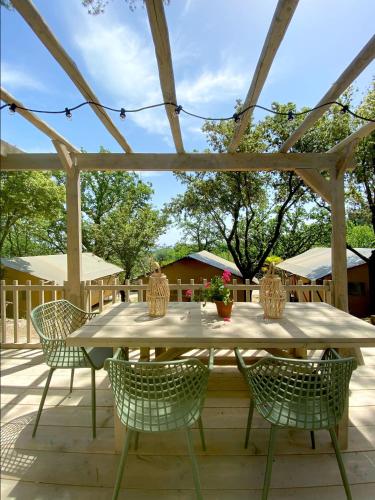 a wooden table and chairs on a patio at Camping Village Mar y Sierra in San Costanzo