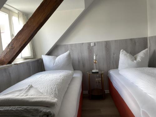 2 łóżka pojedyncze w pokoju z 2 oknami w obiekcie H&H Apartment im Herzen von Greifswald Zentral in der Langen Reihe w mieście Greifswald