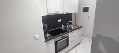 a white kitchen with a sink and a stove at Joanna in Katerini