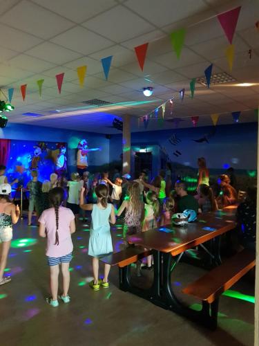 a group of people dancing in a room at Strandcamping Valkenisse in Biggekerke