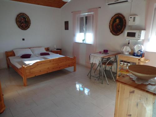 a bedroom with a bed and a table in it at Studio apartman Kata Nin in Nin