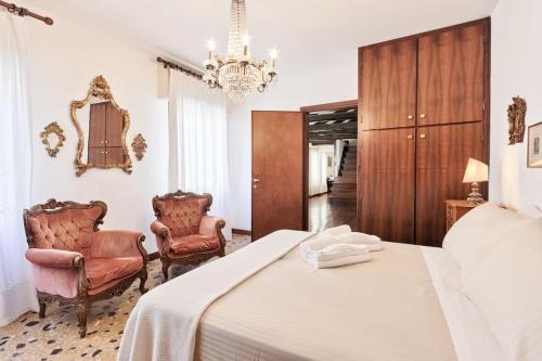 a bedroom with a bed and two chairs at San Marco Bell Tower House in Venice