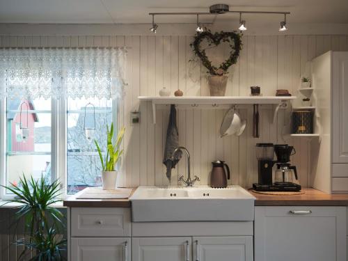 a kitchen with a white sink and a window at Lofoten- Fishermans logde with the view in Stamsund