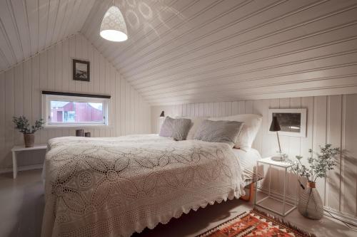a bedroom with a white bed and a window at Lofoten- Fishermans logde with the view in Stamsund