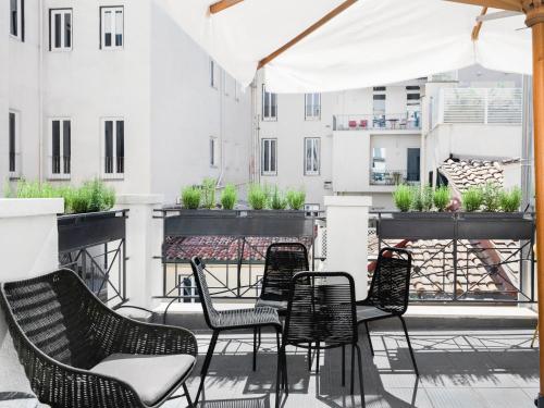 grupa krzeseł i stołów na balkonie w obiekcie numa I Vici Rooms & Apartments w Rzymie