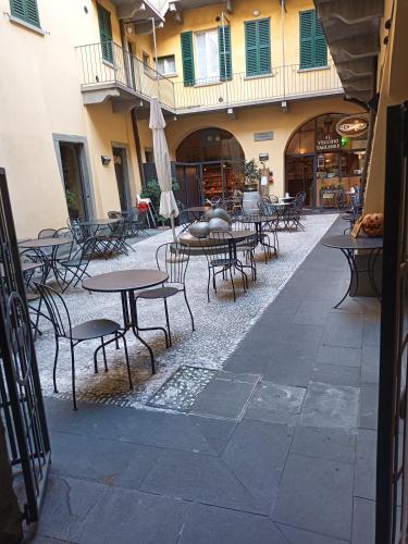 an empty courtyard with tables and chairs in a building at "A casa di Giacomo" Luxury Rooms con aria condizionata in Bergamo