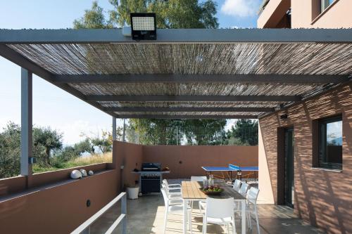 a pergola on a patio with a table and chairs at Villa Niolos II in Stérnai