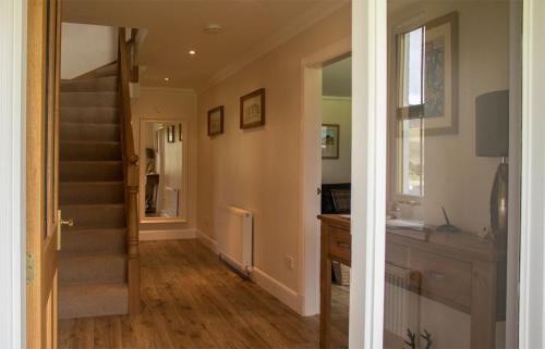 a hallway with a staircase and a stair case at Strath Glebe in Kilbride