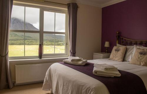 um quarto com uma cama grande e toalhas em Strath Glebe em Kilbride