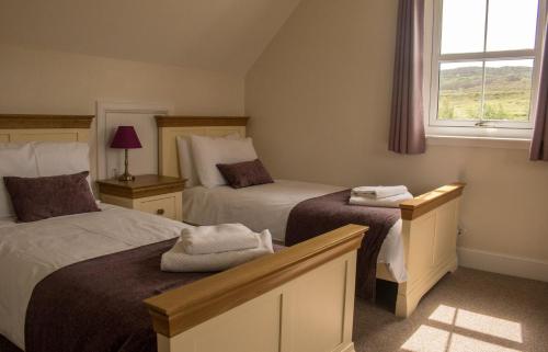 a hotel room with two beds and a window at Strath Glebe in Kilbride