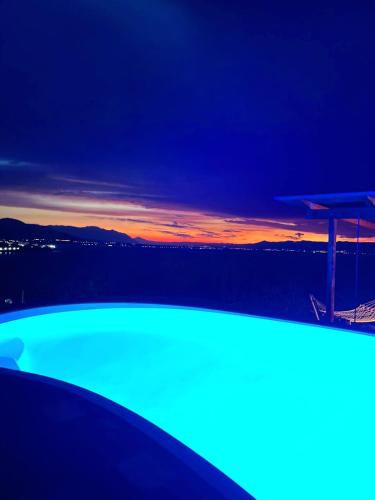 a swimming pool with a sunset in the background at Magical view, Villa Asproneri, Kamena Vourla in Kamena Vourla