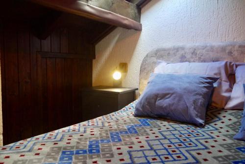a bedroom with a bed with a pillow and a lamp at La Casa Suites Albaredo di Rotzo 