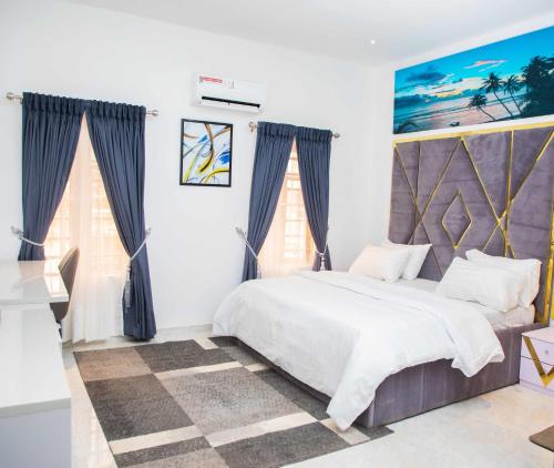 a bedroom with a large bed and two windows at Delight Apartments in Lagos