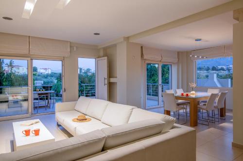 a living room with a white couch and a table at Luxury Villa Alba by Estia in Gouves