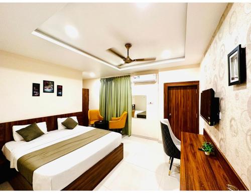 um quarto com uma cama, uma secretária e uma televisão em Sagar Regency And Lodge, Bidar em Bīdar