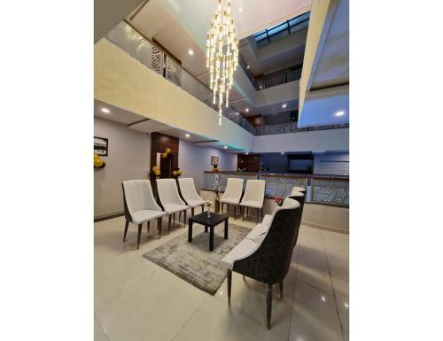 a dining room with chairs and a chandelier at Sagar Regency And Lodge, Bidar in Bīdar