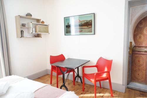 a room with two chairs and a table and a bed at MAS TERRE Chambres d'Hôtes in Lezoux