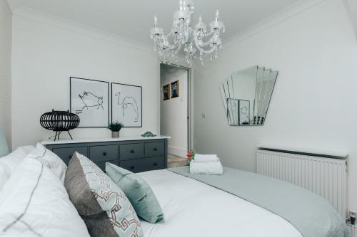 a bedroom with a white bed and a chandelier at Central Hidden Gem in Henley on Thames