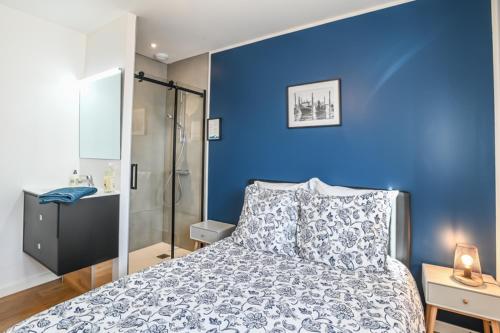 a blue bedroom with a bed and a shower at - SUBLIME VILLA FELICIDAD - Proche hypercentre - Parking - Terrasse - WiFi in Viriat