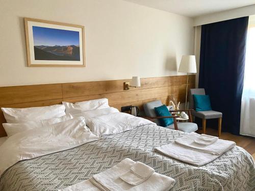 a bedroom with a large bed with towels on it at Dharma City in Florennes