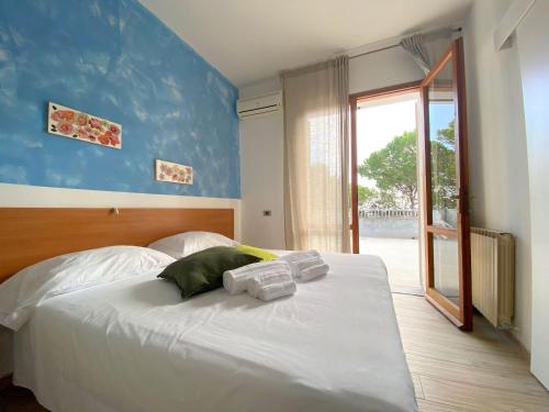 um quarto com uma cama branca e toalhas em Camping Village Mar y Sierra em San Costanzo