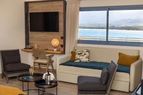 a living room with a couch and a large window at Hotel L'Acquale in Calvi