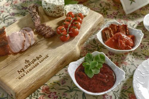 Ein Tisch, auf dem ein Schneidebrett mit Fleisch und Tomatensoße liegt. in der Unterkunft Agroturystyka nad jeziorem Sopień in Brzozie