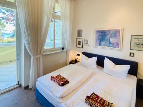1 Schlafzimmer mit 2 weißen Betten und einem Fenster in der Unterkunft Villa Caprivi 8 in Heringsdorf
