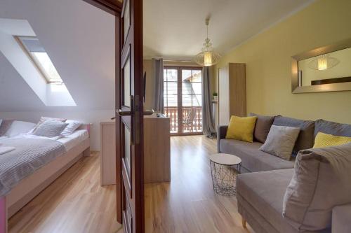 a living room with a bed and a couch at Trevilles Ap.- Martynówka in Szklarska Poręba