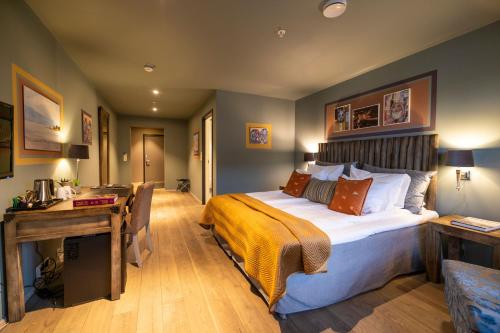 a hotel room with a large bed and a desk at Knutholmen in Kalvåg