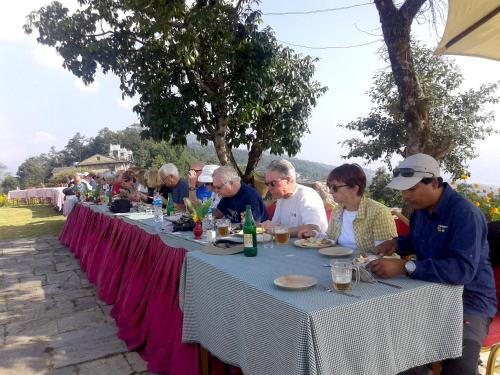 a group of people sitting at a table eating at Himalayan Deurali Resort in Pokhara