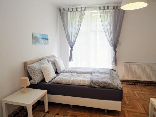 a bedroom with a bed in front of a window at City Villa Schönbrunn Apartments - Contactless 24h Check-In in Vienna