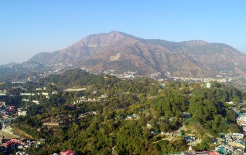 a mountain view of a town with trees and houses at Solan Retreat in Solan