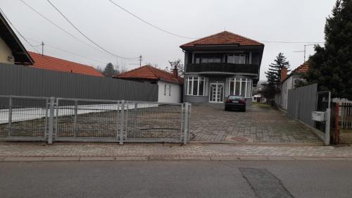 un portail en face d'une maison avec une clôture dans l'établissement Sobe OLGA, à Čačak