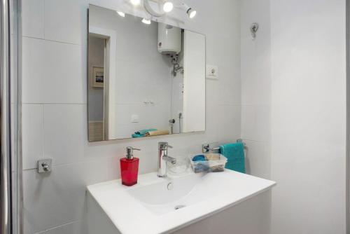 een witte badkamer met een wastafel en een spiegel bij La Garita beach in La Garita