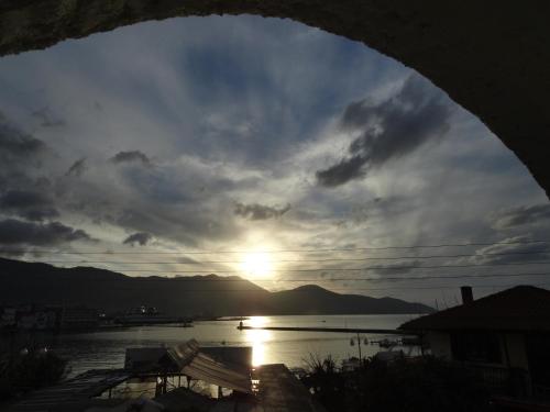 a view of the sun setting over a body of water at Captain's Beach Apartments in Limenas