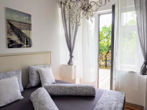 a living room with a couch and a chandelier at City Villa Schönbrunn Apartments - Contactless 24h Check-In in Vienna