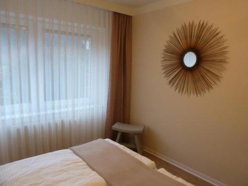 Schlafzimmer mit einem Bett und einem Wandspiegel in der Unterkunft Antoinettes Ferienwohnung in Ilmenau