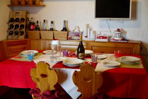 a table with plates and a bottle of wine on it at La Casa Suites Albaredo di Rotzo in Albaredo