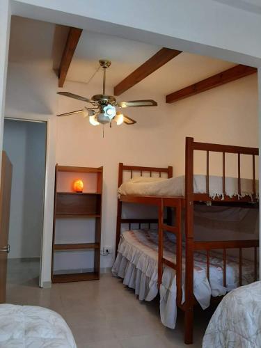 a bedroom with two bunk beds and a ceiling fan at Cabañas Cerros Azules en La Rioja Alojamiento Temporario in La Rioja