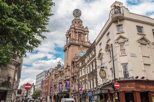 a building with a clock tower in the middle of a street at Central London (West End) two bedroom flat in London