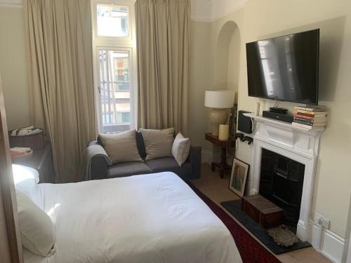 a living room with a bed and a flat screen tv at Central London (West End) two bedroom flat in London