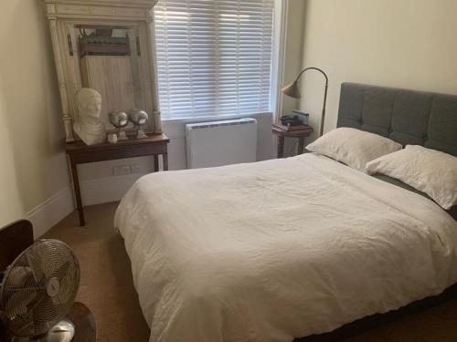 a bedroom with a large white bed and a fan at Central London (West End) two bedroom flat in London